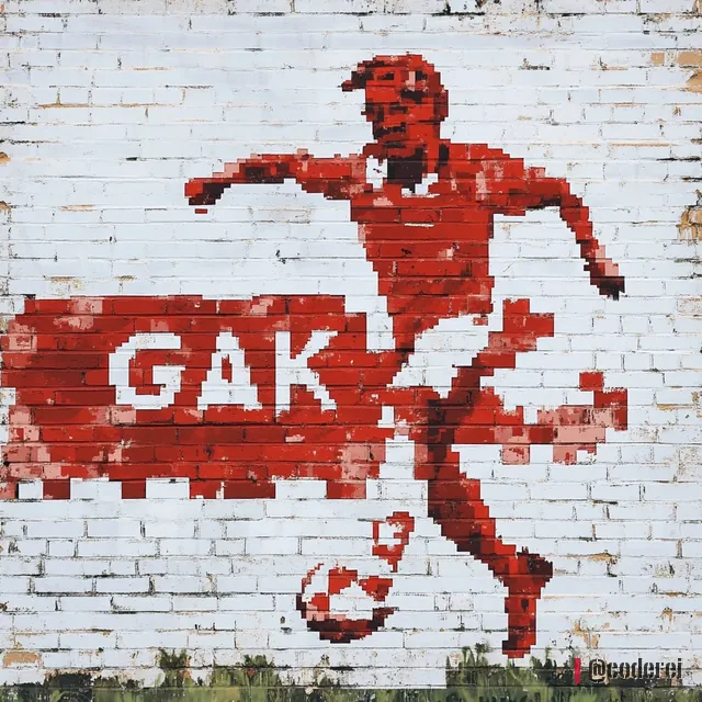 Pixelige rote Figur eines Fußballers mit Ball neben dem Schriftzug „GAK“ auf weißer Ziegelwand.